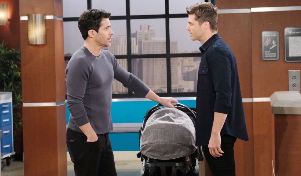 Shawn and Evan face each other near the nurses' station.  The stroller is between them