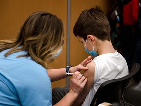 An 11-year-old boy receives a COVID-19 vaccine from Pfizer-BioNTech on November 24, 2021 in Montreal.