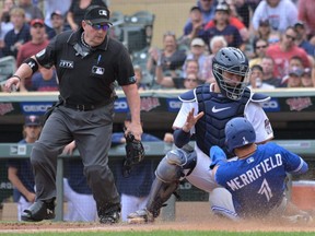 Blue Jays second baseman Whit Merrifield (1) is first hit by umpire Marty Foster (left) at the plate on a tag by Twins catcher Gary Sanchez during the 10th inning at Target Field in Minneapolis, Sunday, August 7, 2022 , summoned.  The call was challenged and knocked over by the Blue Jays, putting Merrifield safe in the game as the catcher blocked the plate.