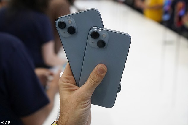 A person holds new iPhone 14 models at an Apple event at Apple's headquarters campus in Cupertino, California on Wednesday