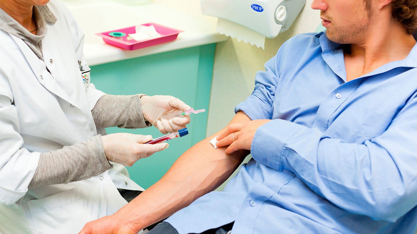 A photo of a man having blood drawn by a female nurse for an STI test.