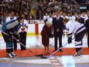 Her Royal Highness Queen Elizabeth II drops the puck October 6, 2002 during a ceremonial duel between Vancouver Canucks captain Markus Naslund and San Jose Sharks player Mike Ricci.