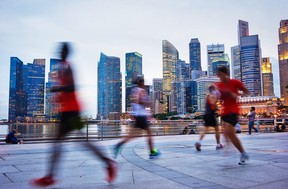 Men run in Singapore in the evening.  files