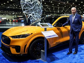 U.S. President Joe Biden stands next to a Ford Mustang Mach-E (electric) SUV during a visit to the Detroit Auto Show to highlight EV manufacturing in America, in Detroit, Michigan, the United States, September 14, 2022.