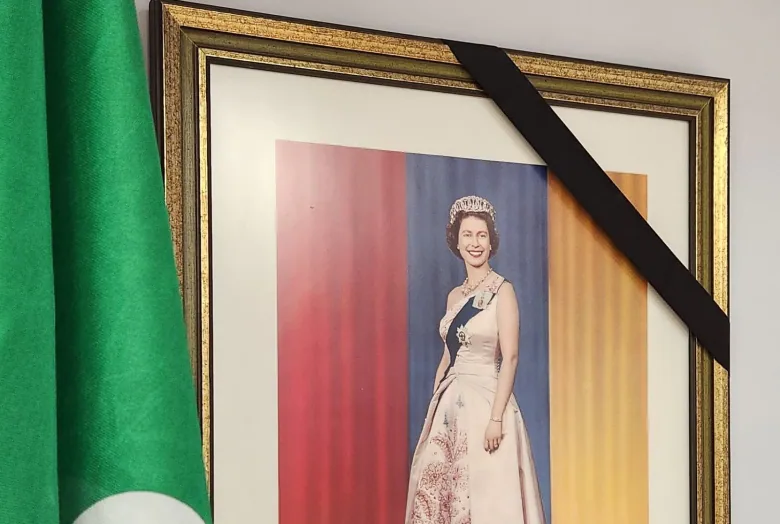 A picture of Queen Elizabeth II hangs in the Timmins Mayor's Office next to the French Ontarian flag with a black band across one corner.