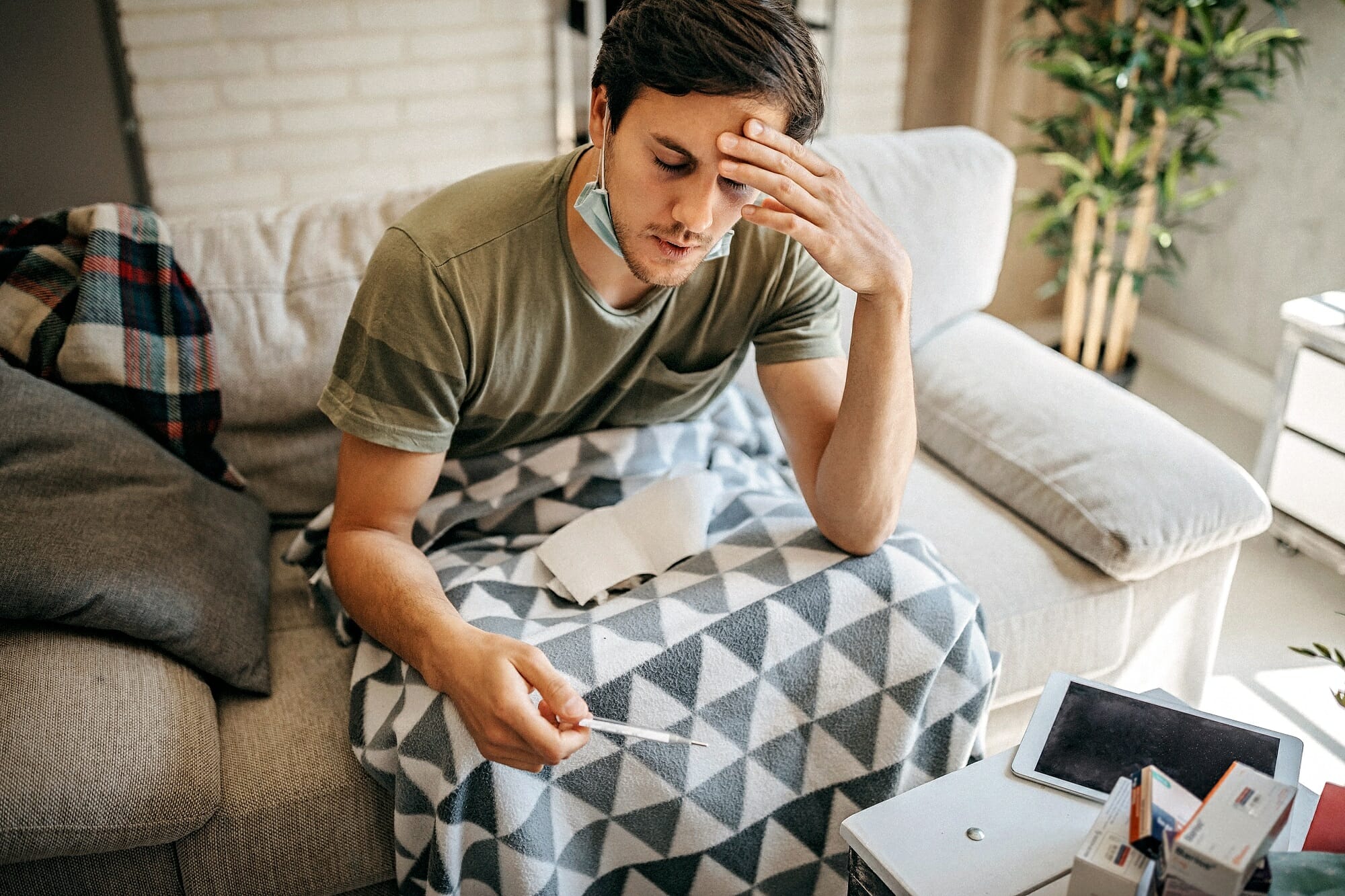 sick man taking temperature