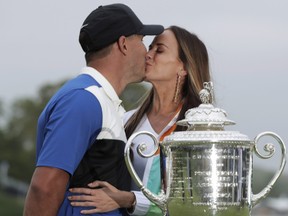 Brooks Koepka, left, kisses Jena Sims after winning the PGA Championship golf tournament on Sunday, May 19, 2019 at Bethpage Black in Farmingdale, NY