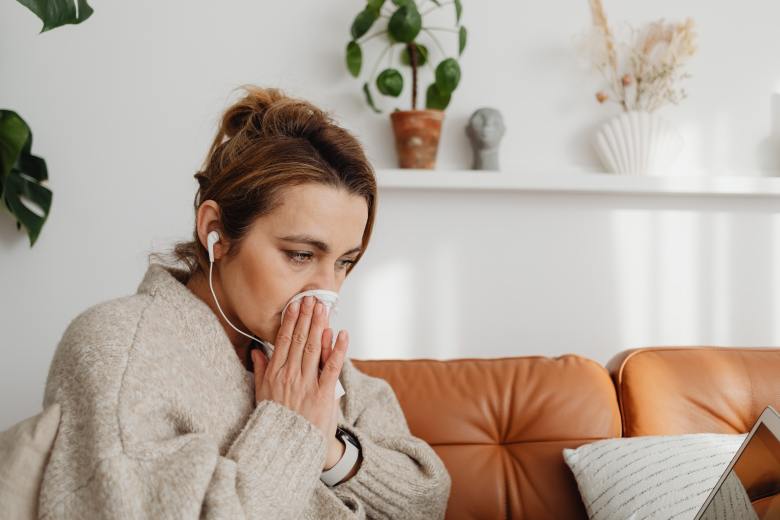 A woman blows her nose.