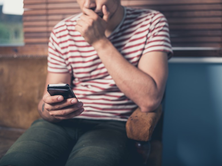 A man looks at his cell phone.