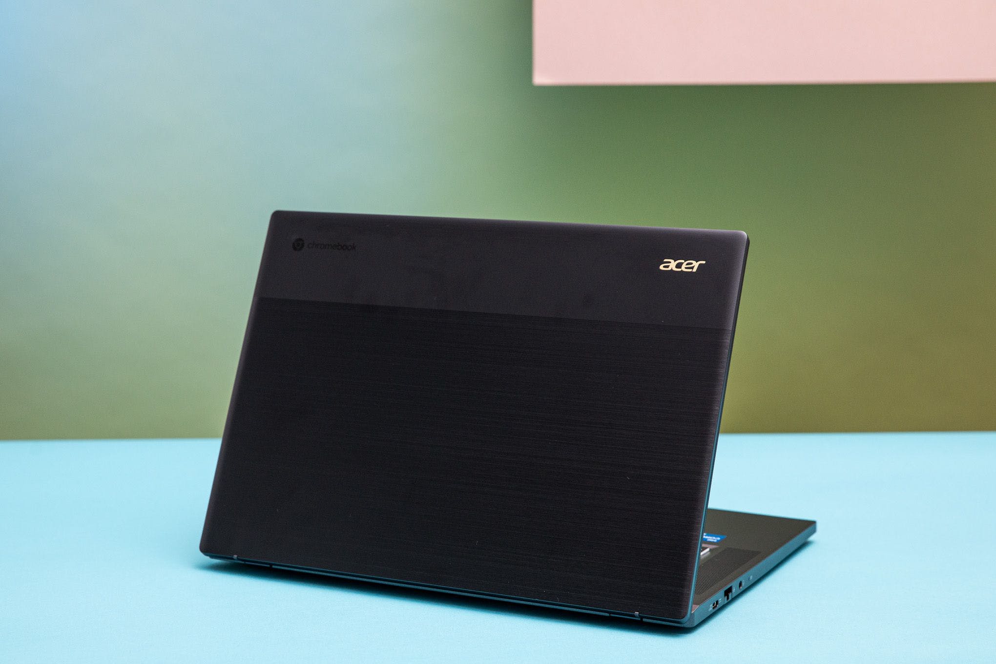 The Acer Chromebook 516 GE was facing away from the camera, revealing its two-tone display lid.  Most of it is a brushed texture while a sliver of it appears anodized with a soft touch.