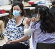 RN Grace Oloresisimo gives Lillian May an injection on Wednesday October 12, 2022 at a UBC Flu and COVID Vaccine Clinic in Vancouver, BC. 
