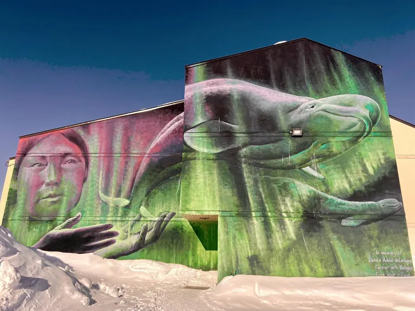 A Churchill mural by artist Charlie Johnston depicts a beluga swimming through the Northern Lights.