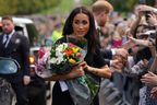 Meghan, Duchess of Sussex, collects flowers while chatting to well-wishers on the Long Walk at Windsor Castle on September 10, 2022, two days after the death of Britain's Queen Elizabeth II at the age of 96.  (Photo by KIRSTY O'CONNOR /POOL/AFP via Getty Images)