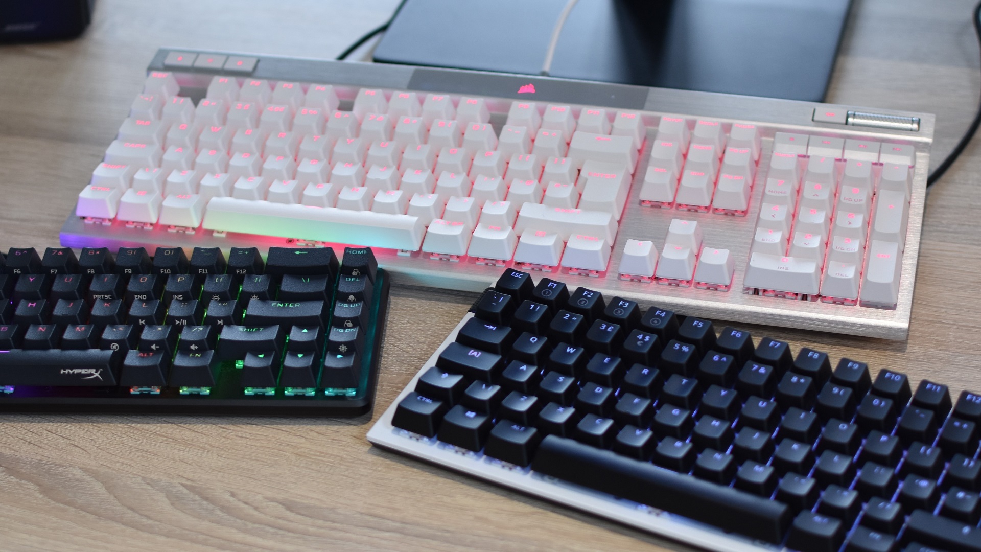 Three different models of mechanical gaming keyboards on a desk.