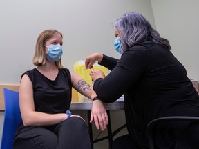 Sarah Peterson receives the flu vaccine from Registered Nurse Anna McGillivray as Alberta's influenza vaccination campaign begins Monday, October 17, 2022 in Edmonton for all Albertans six months of age and older.  COVID-19 vaccines, including booster shots, may also be offered to people who are eligible for any flu vaccination appointment booked.