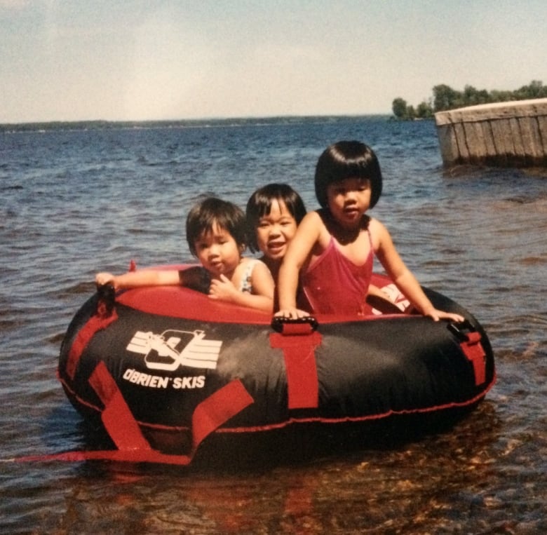 Three girls on a float in a lake.