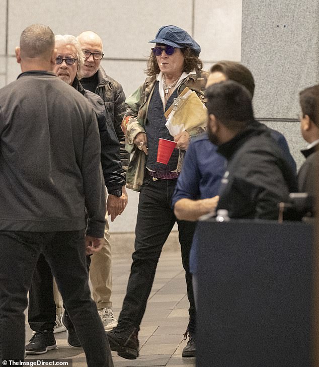 Rock on: Johnny Depp looked in the party mood as he was seen clutching a solo red mug again on Monday as he stepped out with rocker Jeff Beck in Toronto