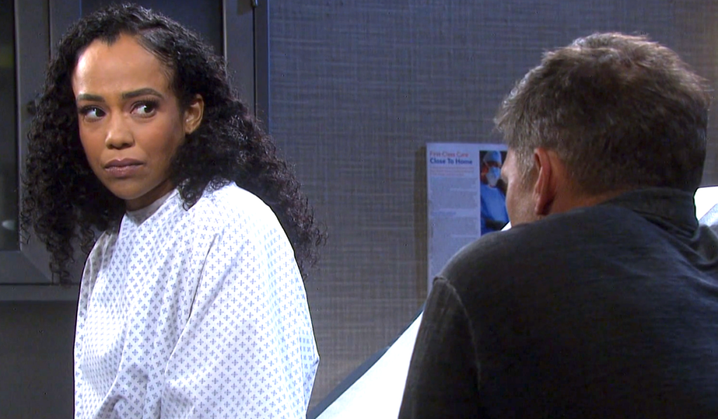 In a patient's room, Jada is wearing a hospital gown and is sitting on an exam table.  She directs her somber gaze at Eric, who is sitting next to the table.